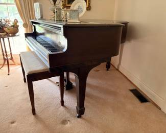 Mahogany baby grand piano with bench in living room