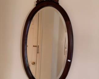 Antique oval mahogany wall mirror with carved crest