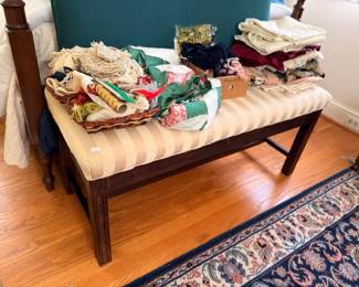 Striped upholstered bench with linens table runners and holiday fabrics
