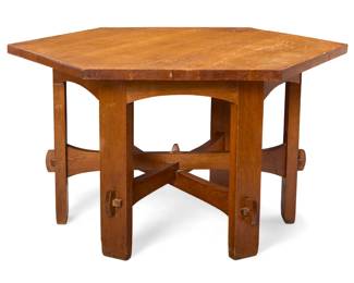 1073 A Gustav Stickley hexagonal library table, no. 625 1907-1912 Numbered to partial applied Craftsman Workshops label Quarter sawn oak, the base joined by an overlapping stretcher with keyed mortise and tenon construction 29.75" H x 54.75" W x 47" D Estimate: $2,000 - $3,000
