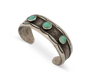 1347 A Southwest sandcast ingot silver and turquoise cuff bracelet Mid/late 20th century Stamped: E A chunky cuff with three set turquoise stones and stamped edge accents 6.25" total inner C x 0.875" H, gap:1.25" 51.6 grams gross Estimate: $500 - $700