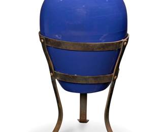 1010 A Bauer blue glazed pottery oil jar on stand Circa 1930s Unmarked Set in a wrought-iron tripod stand Jar: 21.25" H x 17" Dia.; Stand: 21.5" H x 21.25" W x 21.25" D Estimate: $700 - $900