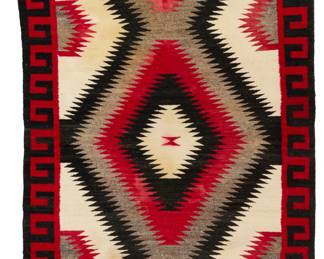 1216 A Navajo regional rug Mid-20th century, Diné Woven in black, red, cream, and natural grey wool, with central stacked serrated diamonds and a hooked long edge border 82.5" H x 47" W Estimate: $500 - $700