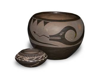 1158 Two Santa Clara Pueblo blackware pottery vessels Two works:  Nicolasa Naranjo (1907-2002, Santa Clara Pueblo) A blackware pottery jar, mid/late 20th century Incised to underside: Nicolasa / Santa Clara With black on black Avanyu serpent design 4.625" H x 6.625" Dia.  Geri Naranjo (b. 1952, Santa Clara Pueblo) A miniature sgraffito blackware vessel, late 20th/early 21st century Incised to underside: GERI / NARANJO / SANTA / CLARA The shoulder carved with banded feather and Avanyu motifs, the body carved with kiva step, feather, and geometric motifs 1.75" H x 3.625" Dia.  2 pieces Estimate: $200 - $400