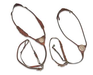 1101 Two leather horse tack martingales including Edward H Bohlin 20th century One stamped to leather: Bohlinmade / Hollywood / Calif. Comprising two brown leather martingales each featuring chased sterling silver medallions and buckles, including an Edward H Bohlin martingale with silver ferrules, and the other martingale with a sterling silver and 9K gold medallion and tooled leather decorated elements, each with smaller strap clipped to end 2 pieces Larger: 56" L x 5.5" W; Smaller: 48" L x 4" W Estimate: $500 - $700