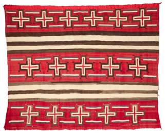 1041 A Navajo wearing blanket variant with spider woman crosses Early 20th century, Diné Woven in non plied wool with rows of red spider woman crosses alternating with natural cream and dark brown bands 63" H x 75" W Estimate: $5,000 - $7,000