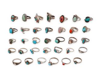 1396 A large group of Southwest style silver and stone set rings Mid/late 20th century Sixteen variously marked for maker and/or for sterling: B / OTT © / Teme [Sunburst Handcrafts] / [Bell Trading Post] / [Wheeler Manufacturing of Lemon] / M. Will D [Danz Ltd] / DJ [or JD] / CR [Carolyn Pollack Relios Inc.] A group of diminutive silver rings in various colors and sizes, most with single set stones including turquoise, coral, mother of pearl, and in various styles including a shadowbox set oval ring with spiny oyster and lapis lazuli stone inlay, a silver overlap ring with stepped Pueblo motif and row-set gemstones, a Fred Harvey-style Thunderbird motif ring, a silver scorpion motif ring, and a reversible turquoise and amber ring with narrow swivel bands, as well as other single set stone rings with silver feather, geometric, and twisted wire overlay and edge accents 34 pieces Ring sizes: 9 to 1.5 106.4 grams gross Estimate: $300 - $500