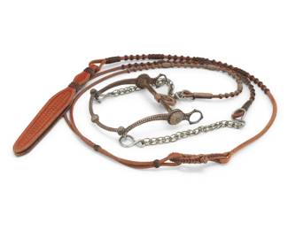 1105 An E.G. Field sterling silver and mixed metal bit & California Classics hide reins Early 21st century Stamped to bit: E.G. Fields / Stamped to reins: California Classics / Maker / Templeton, CA Comprising a mixed metal and sterling silver bit with chain extensions, and sueded hide reins with multiple woven leather buttons and a heavy tooled leather popper end 2 pieces Bit: 9" H x 6.5" W; Reins: 90" L total Estimate: $600 - $800