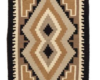 1238 A Navajo Two Grey Hills textile Mid/late 20th century, Diné Attributed to Margret Lewis A small tapestry-woven textile woven in tan, light and mid grey, light brown, black and cream wool with central conjoined stepped diamonds, stepped corners and a denticulated border to sides 33" H x 21.25" W Estimate: $300 - $500