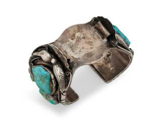 1349 A Southwest sterling silver and turquoise watch cuff bracelet Mid/late 20th century Unmarked A chunky shaped watch cuff bracelet with multiple set turquoise nuggets and applied silver feather, ball, and wire accents 7.125" total inner C x 1.875" H, gap: 1.125" 178.0 grams gross Estimate: $300 - $500