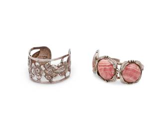 1351 Two Southwest style silver cuff bracelets Mid/late 20th century Two works:  A Maciel's Mexican sterling silver cuff bracelet Stamped: Maciel'_ / Sterling / Made in Mexico / 925/1000 An openwork repoussé sterling silver cuff with floral motifs 6.5" inner C x 1.375" H, with a 1" gap  A Southwest-style silver and set stone cuff bracelet Marked: 925; and with double-struck illegible maker's mark A two-wire cuff with three set pink striped rhodochrosite cabochons with silver overlay feather motifs 6.75" inner C x 1.375" H, with a 1.125" gap  2 pieces 81.1 grams gross Estimate: $200 - $400