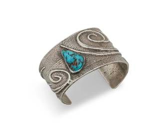 1341 A Preston Monongye Hopi silver and turquoise cuff bracelet Preston Monongye (1927-1987, Mission/Hopi) Mid/late 20th century Marked to plaque with artist's Peyote bird picto A wide tapered chunky cuff in cast silver with applied wire botanical accents and a set turquoise oblong cabochon 6.375" total inner C x 1.75" H, gap: 1.5" 93.4 grams gross Estimate: $2,000 - $3,000
