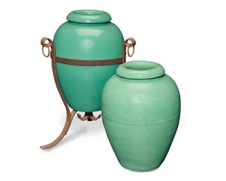 1004 Two Bauer green glazed pottery oil jars Circa 1930s One impressed: BAUER POTTERY CO. / LOS ANGELES CAL.; and incised: 16" One set in a wrought-iron scrollwork stand with rings 2 pieces Each jar: 15.375" H x 11.75" Dia. approximately; Stand: 17.75" H x 15.75" W x 16.5" D Estimate: $700 - $900
