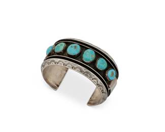1346 An Alice Sam Navajo silver and turquoise cuff bracelet Alice Sam (b. 20th century, Diné) Late 20th/early 21st century Stamped: Alice Sam A chunky cuff with six shadow set turquoise cabochons and ridged stamped edges 6.5" total inner C x 1.375" H, gap: 1.375" 75.8 grams gross Estimate: $400 - $600