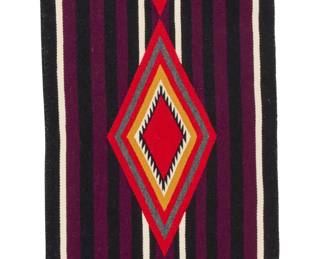 1242 A Charlene Laughing Navajo Moki wearing Blanket Revival textile Late 20th/21st century, Diné Woven in red, orange, grey, purple, black, and cream wool featuring a band of concentric diamonds with serrated centers over striped banding to each side 40.75" H x 19.5" W Estimate: $500 - $700