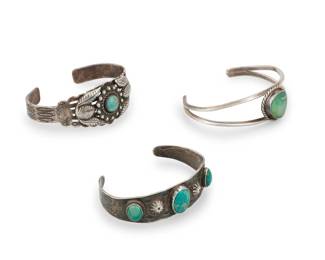 1382 A group of Fred Harvey style Southwest silver cuff bracelets Mid-20th century One stamped: Sanford [for Sanford & Co.] Comprising a tapered multiwire cuff with central turquoise, stamp work, and silver feather overlay, a small cuff with three set turquoise stones and stamp work accents, and a two-wire cuff with central set oblong turquoise 3 pieces Largest: 6.5" inner C x 0.75" H, gap: 1.5"; Smallest: 6" inner C x 0.625" H, gap: 1.25" 63.8 grams gross Estimate: $300 - $500