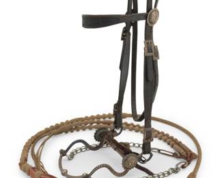 1103 A California Classics & E.G. Field leather and sterling silver headstall bridle & reins Early 21st century Bridle and reins stamped: California Classics / Maker / Templeton, CA; Bit stamped: E.G. Field / 2007 Comprising a California Classics dark brown tooled leather fancy bridle with two chased sterling silver concho rosettes and multiple sterling buckles, a 2007 E.G. Field mixed metal 'half breed' bit with deep striped chasing and applied sterling silver rosettes and buttons, and a set of California Classics braided rawhide romal ortega-style reins with multiple woven rawhide buttons and a heavy tooled leather popper end, with chain extensions Headstall: 38.5" L; browband: 15.5" L; bit: 6" W; reins: 98" L total Estimate: $800 - $1,200