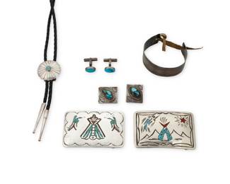 1385 A group of Southwest silver jewelry Late 19th/20th century Six works:  Willie Nezzie (b .1950, Diné) A Navajo turquoise and coral chipped mosaic inlay belt buckle Stamped: WN With pictorial landscape and "teepee" motif and peyote bird 2.125" H x 3.125" W  A group of Southwest sterling silver jewelry Cuff marked: Montreal / RC [or G, in script] Comprising a thin ridged sterling silver Plains cuff bracelet with pierced terminals, with a leather cord, a sterling silver turquoise and coral chipped mosaic inlay pictorial belt buckle with "teepee" and peyote bird motifs, and a bolo tie with concho-button style slide with set turquoise, on a braided black leather cord with silver tips, as well as pair of set turquoise cuff links and a pair of turquoise set buttons 7 pieces Cuff: 5.5" L x 0.875" H; Buckle: 2" H x 3" W; Bolo: 36.5" L x 1.25" Dia.; Cuff links: 0.5" H; Buttons: 1" H  8 pieces total 146.0 grams gross Estimate: $300 - $500
