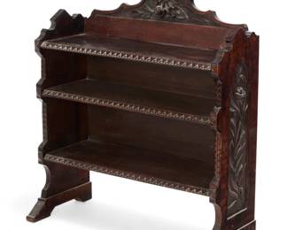 1224 An American carved walnut bookcase Late 19th century Carved with calla lilies in relief to sides and a floral element in relief to pediment, with stylized trimming to front edges 38.25" H x 33.25" W x 14" D Estimate: $300 - $500