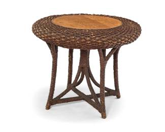 1308 An American wicker and oak side table Early 20th century With quarter-sawn oak top mounted to a woven wicker body with X-form base 22" H x 27.5" Dia. Estimate: $200 - $400
