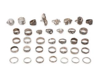 1412 A group of Southwest style silver rings Mid/late 20th century Most variously marked for maker and/or for sterling: LL BCT [Lloyd Becenti, Navajo/Diné] / L. Chee Navajo / S [Shube's] / Mexico / Masha / V / CJ [Carlisle Jewelry Albuquerque] / CR [Carolyn Pollack / Relios Jewelry Co] / CJ / B. Chee [Navajo/Diné] / RJP Mexico / [Eagle 3] / A.J.Nunc / J.A. [James Avery] Comprising thirty-six rings in various sizes and styles, including some with Storyteller pictorial silver overlay with figures, animals, hogans, weavers, and katsina mask motif, some bands with heartline bears, narrow silver bands with stamped motifs including Fred Harvey-style arrows and feathers, Pueblo motifs, and also with incised geometric lines and three with silver wire, feather, and floral overlay as well as other rings with insect motifs, and scrollwork bands 36 pieces Ring sizes: 11 to 4.75 165.3 grams gross Estimate: $200 - $400