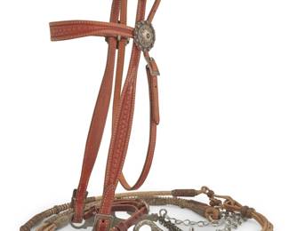 1104 A California Classics tooled leather and sterling silver headstall bridle & reins Late 20th/21st century Stamped to leather: California Classics / Maker / Templeton, CA; stamped to bit: JWP [within spur icon, for Jeremiah Watt]; reins: Jedlicka's / Santa Barbara Comprising a Western-style tooled tan brown leather headstall bridle with sterling silver concho-style rosettes, buckles and applied chased sterling ornamentation to the Jeremiah Watt half breed bit, with braided rawhide romal-style reins with multiple woven leather buttons and heavy tooled leather popper end, with chain extensions. Headstall: 42" L; browband: 15" L; bit: 5.75" W; reins: 94" L total Estimate: $600 - $800