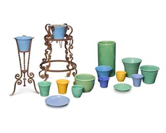 1274 A group of Bauer glazed pottery planters and two stands Circa 1930s One drip tray impressed: BAUER POTTERY CO/ / LOS AGELES / 8; some others with factory impressions and variously marked: 5 / 6 / 10 Comprising 12 planters of various sizes and styles including ringware, 2 undertrays, 1 umbrella stand, and 2 wrought-iron scrollwork stands 17 pieces Umbrella: 19.75" H x 10.5" Dia.; Largest planter: 9.75" H x 11.75" Dia.; Larger stand: 32.5" H x 27" Dia. Estimate: $400 - $600