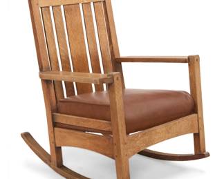 1128 An L. & J. G. Stickley Onondaga rocking chair, no. 751 Circa 1902-1904 Appears unmarked With five-slat back and flat arms above a later upholstered drop-in leather seat cushion, raised on rockers 37.25" H x 27.75" W x 33.5" D Estimate: $700 - $900