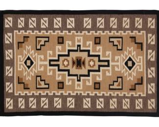 1239 A framed Navajo Two Grey Hills textile Mid/late 20th century, Diné Woven in grey, tan, black, and cream wool with an elaborate hooked diamond to center, sawtooth diamonds to each end and an elaborate hooked border, with a 'spirit line' extending from one corner, professionally mounted and framed 25.25" H x 39" W Estimate: $200 - $400