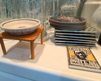 Ceramic bowl on wood stand, stacked plates, vintage Cream of Wheat sign, kitchen lot