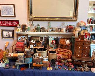 Packed table of antiques, vintage Telephone sign, wooden apothecary cabinet, collectibles