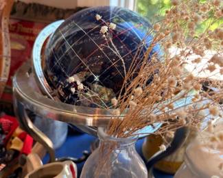 Decorative blue gazing ball on stand with dried floral arrangement