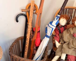 Vintage wooden umbrella stand with umbrellas, handmade cloth dolls, wicker baskets
