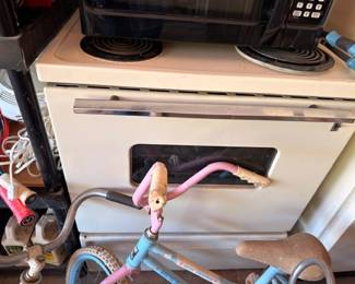 Vintage electric stove range, pink kids tricycle, retro kitchen appliance, garage finds