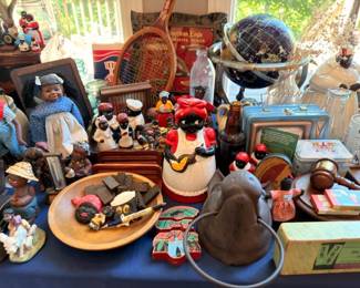 Vintage figurines, globe, derby hat, and American Eagle collectibles on table