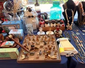 Vintage collectibles table with wooden gavel, figurines, blue mason jar, and Elvis memorabilia