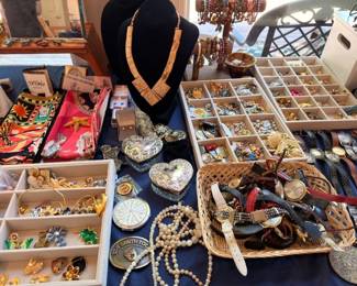 Extensive costume jewelry display with necklaces, brooches, pearls, and gold-tone pieces