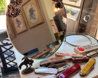 Vintage pocket knife collection, Coca-Cola knives, Swiss Army, bronze cowboy figurine, ornate vanity mirror