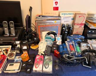 Cordless phones, flashlights, vinyl records, electronics and gadgets table lot