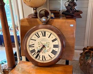 Large round wall clock, Roman numerals, wood accent table, globe, vintage decor