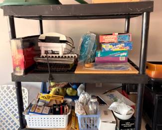 Metal shelf garage items lot, games tools household goods, mixed estate sale finds