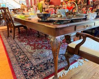 Carved mahogany dining table with upholstered chairs, oriental rug, silver-plated serving pieces