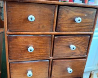 Antique wooden apothecary cabinet with porcelain knob drawers