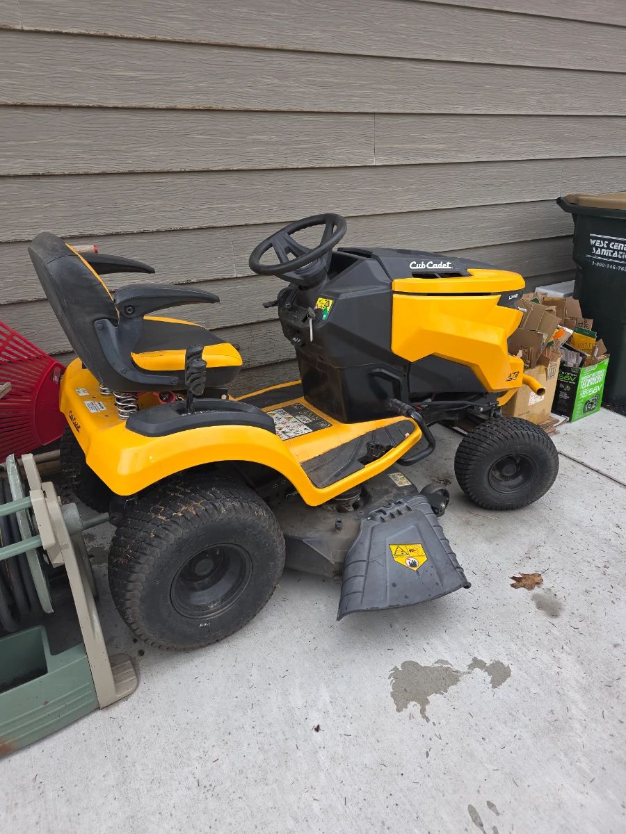This image features a Cub Cadet XT Enduro Series riding lawn tractor, which typically includes a hydrostatic transmission for smooth operation and a 42-inch stamped cutting deck.  Engine: Commonly powered by a 547cc Cub Cadet engine, often with IntelliPOWER technology for consistent power in challenging conditions. 