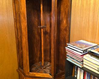 This item is an Amish-style corner gun cabinet designed for displaying firearms, typically featuring solid oak wood construction and a rotating carousel rack. Type: Corner gun display cabinet Capacity: Ranges from 6 to 12 guns depending on the specific model Features: Rotating swivel mechanism, glass display doors, and a lower storage cabinet Material: Usually handcrafted from hardwoods like oak