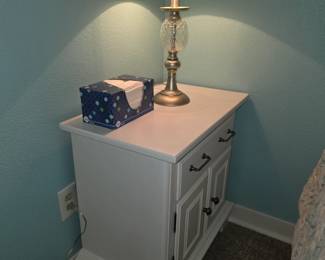 white nightstand appears to be the Enyin cabinet by Acme Furniture, featuring a storage drawer and a two-door cabinet.
