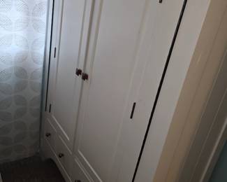 white, painted Edwardian-style wardrobe featuring double doors and drawers below, similar to bespoke designs found from various furniture suppliers.