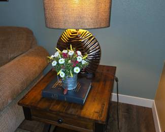 This rustic-style wooden side table features a single drawer, a lower shelf for storage, and distinct X-shaped legs.