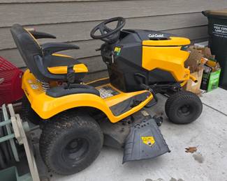 This image features a Cub Cadet XT Enduro Series riding lawn tractor, which typically includes a hydrostatic transmission for smooth operation and a 42-inch stamped cutting deck. Engine: Commonly powered by a 547cc Cub Cadet engine, often with IntelliPOWER technology for consistent power in challenging conditions.