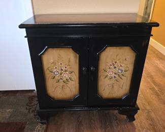 This item appears to be a vintage Italian Tuscan style hand-painted storage console cupboard, featuring black framing and painted tan panels.